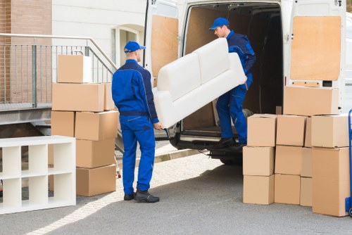 Local house movers unloading boxes and furniture at a new home