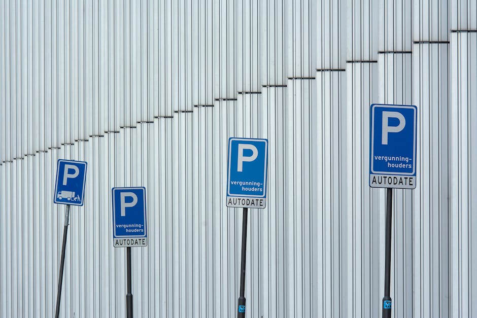 A rectangular white parking permit sign attached to a wooden post in front of a brick wall. The sign includes a blue wheelchair symbol at the top left, indicating accessible parking, and below it, a blue square with a white letter 'P'. To the right of the symbols, the sign displays the text 'Blue badge holders only' in black, clearly specifying parking restrictions for individuals with Blue Badge permits. The sign is positioned outdoors, with natural lighting that casts a slight shadow on the brick wall background. This signage typically appears in areas designated for accessible parking, which is relevant to house removals and moving services by companies like Man with Van Goddington, especially when planning logistics for home relocation or furniture transport. The sign’s purpose is to inform limited parking usage by authorized permit holders, supporting smooth and compliant loading and unloading processes during moves.